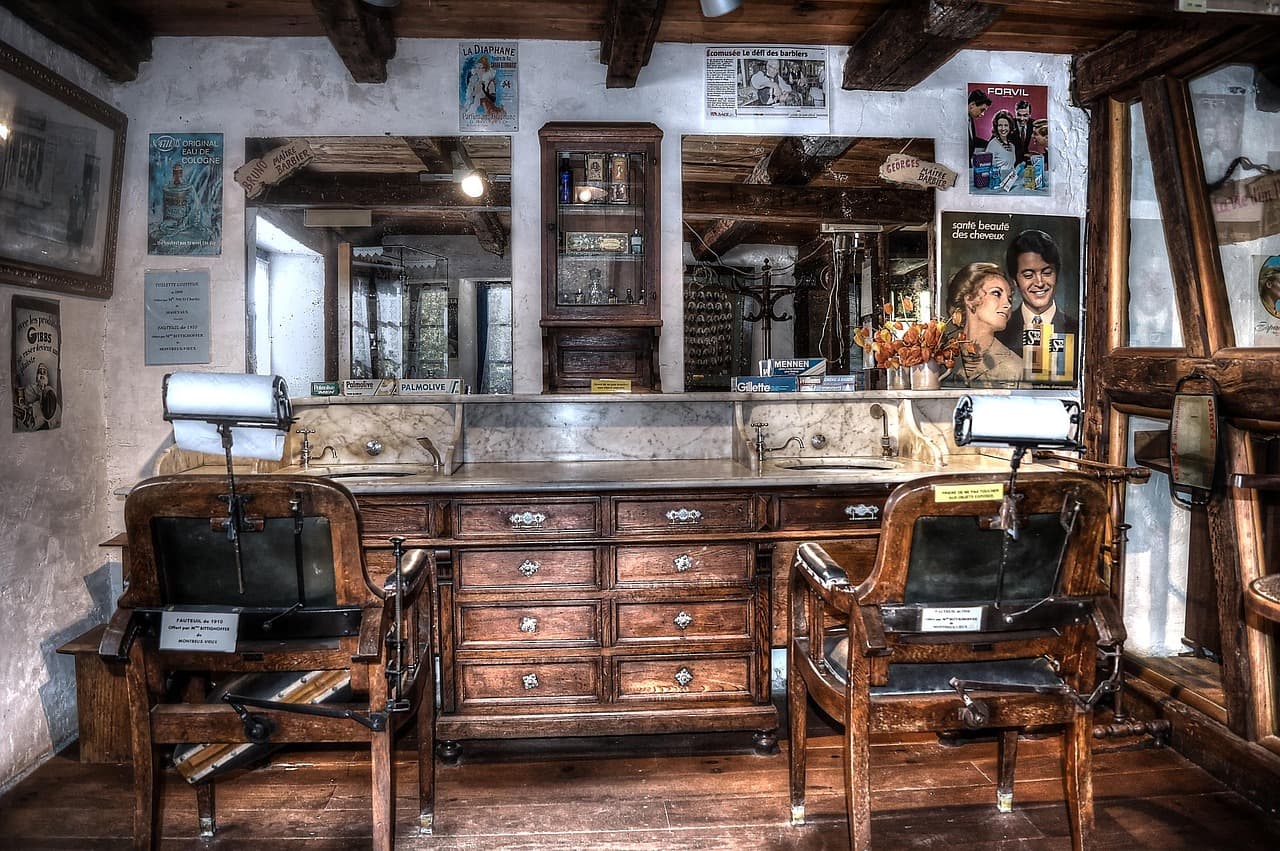 A barber shop with leather chairs and a long wooden counter