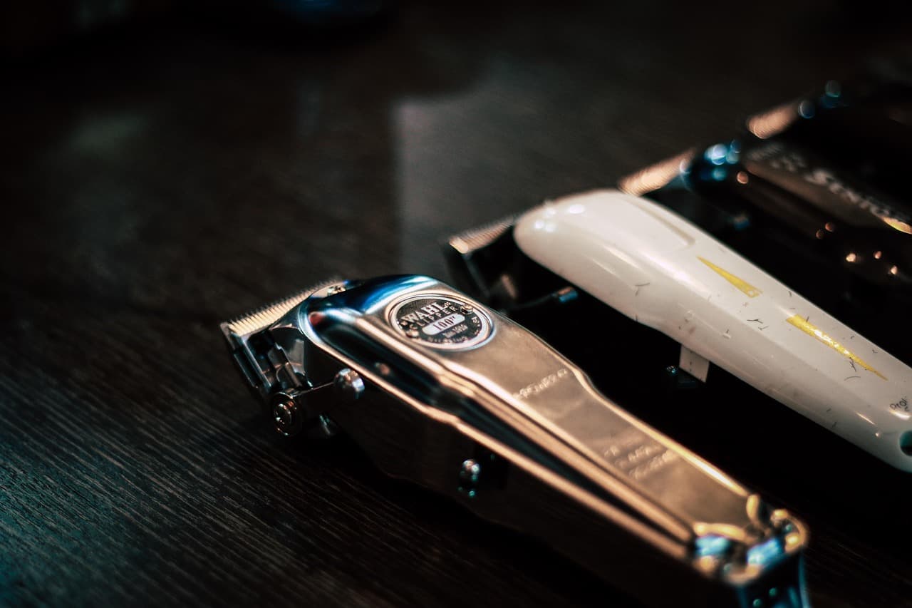 Two pairs of clippers laid on a dark counter