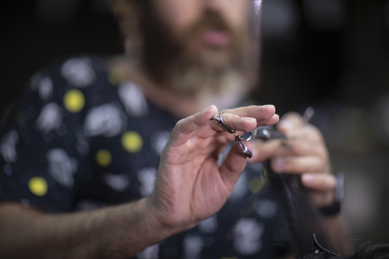 A barber holding his scissors mid-cut