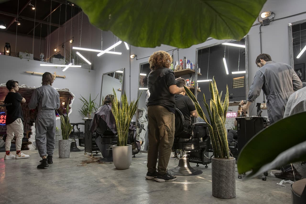 A busy barber shop with barbers at work at every chair
